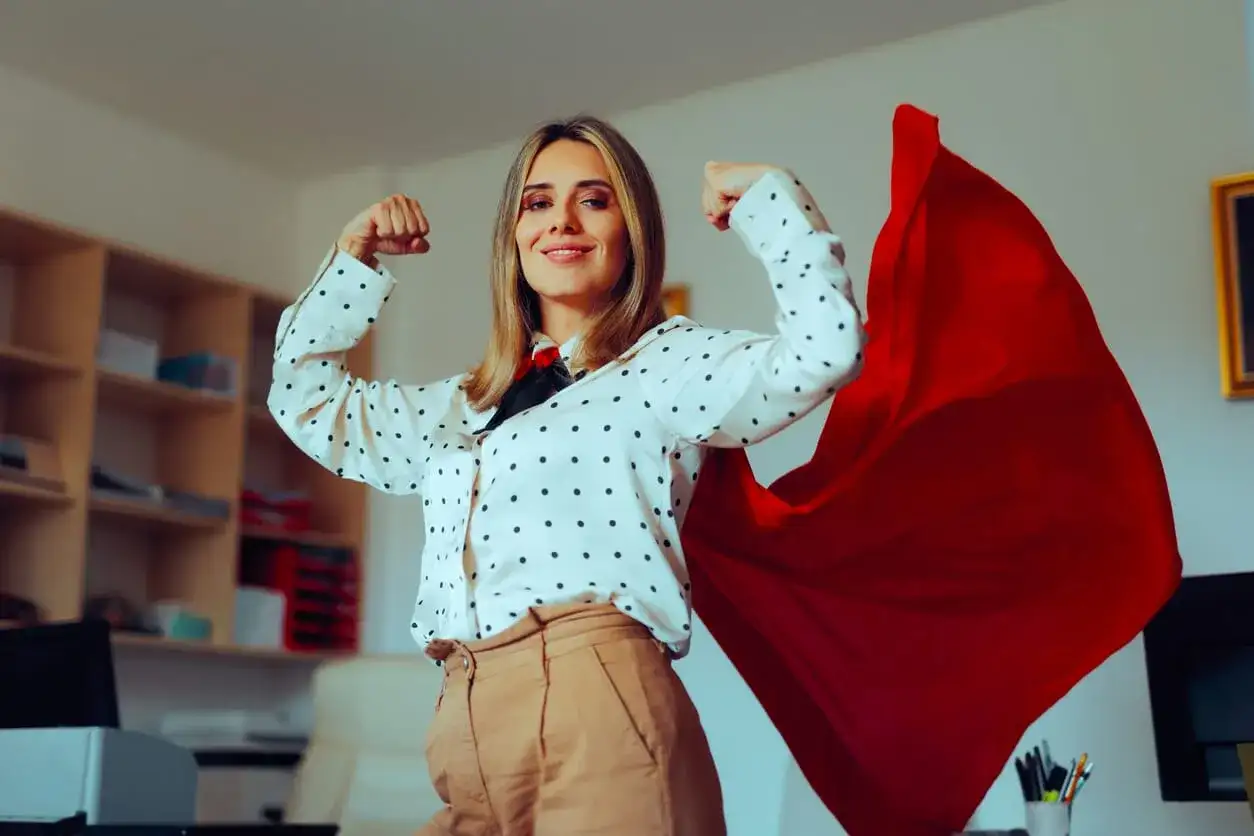 Kobieta w pelerynie superbohatera, gotowa na wyzwania. Inspiracja, jak założyć firmę i osiągnąć sukces.